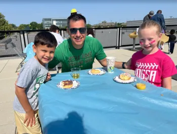 A photo of a dad and his two kids enjoying our Donuts with Dad event!